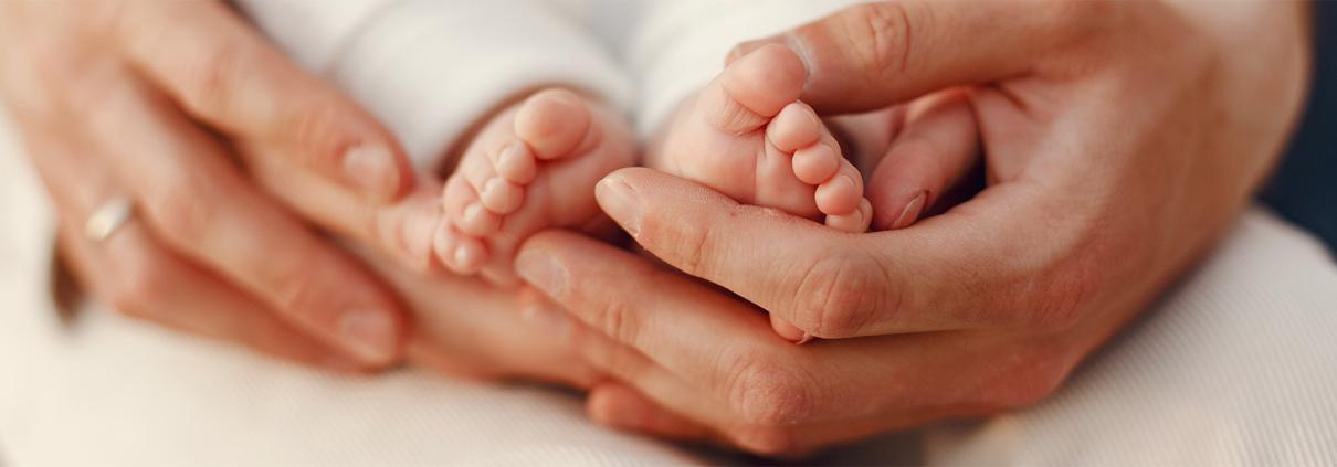 mains de parents et pieds de bébé - EKTC Blog : Accompagner la grossesse et la maternité grâce à la kinésiologie périnatale